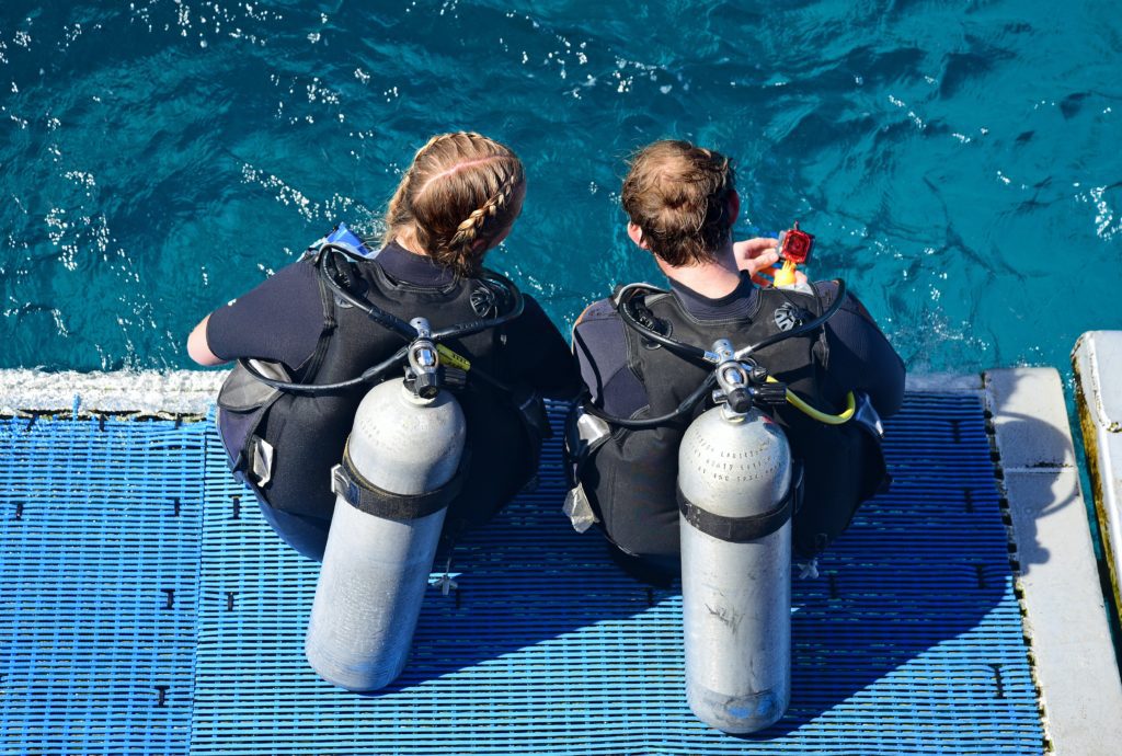 two scuba divers about to enter water