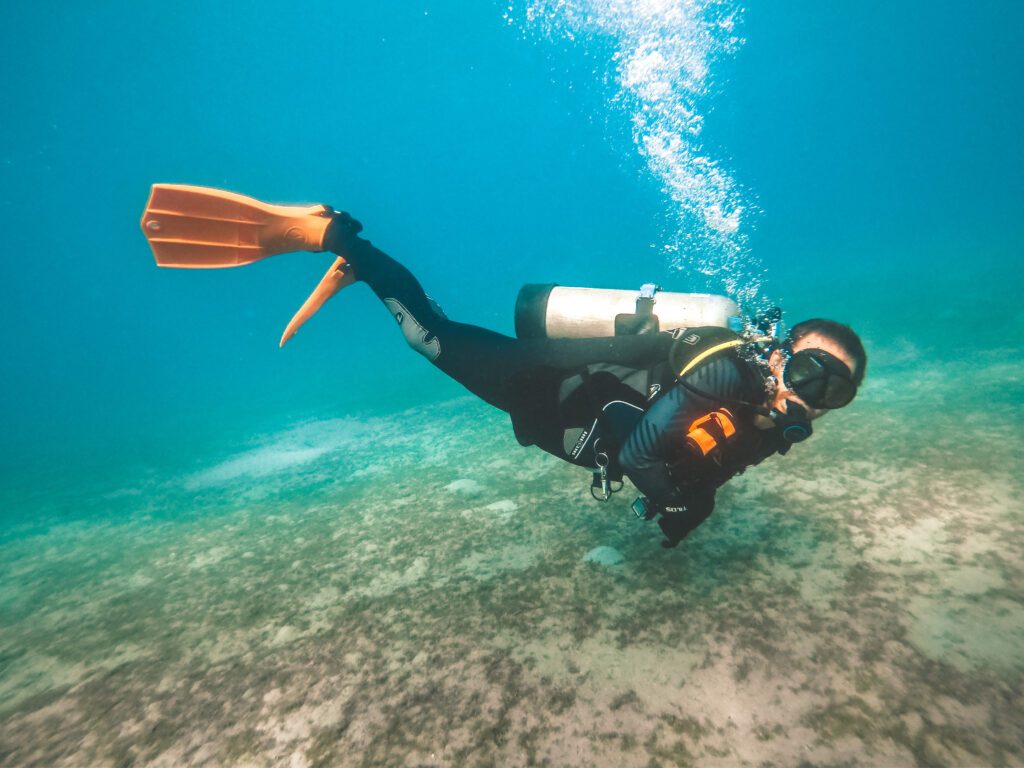 male scuba diver with orange fins underwater