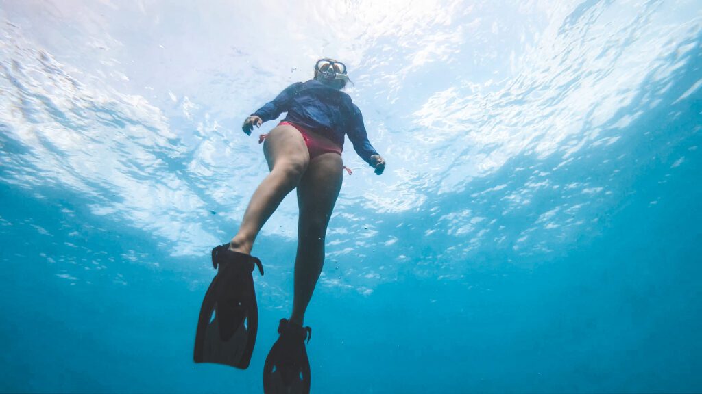 woman free diving underwater in the ocean