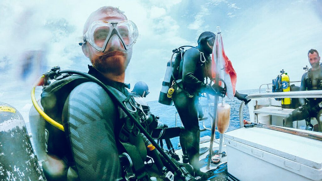 scuba diver on boat with scuba accessories