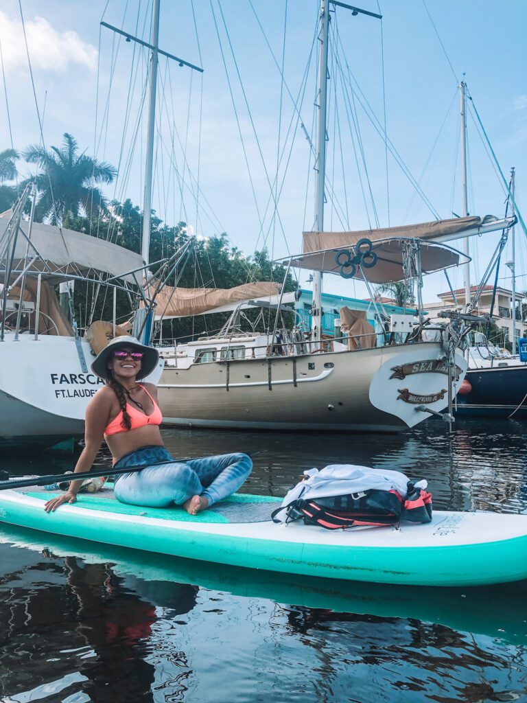 woman by sailboats in fort lauderdale paddleboard