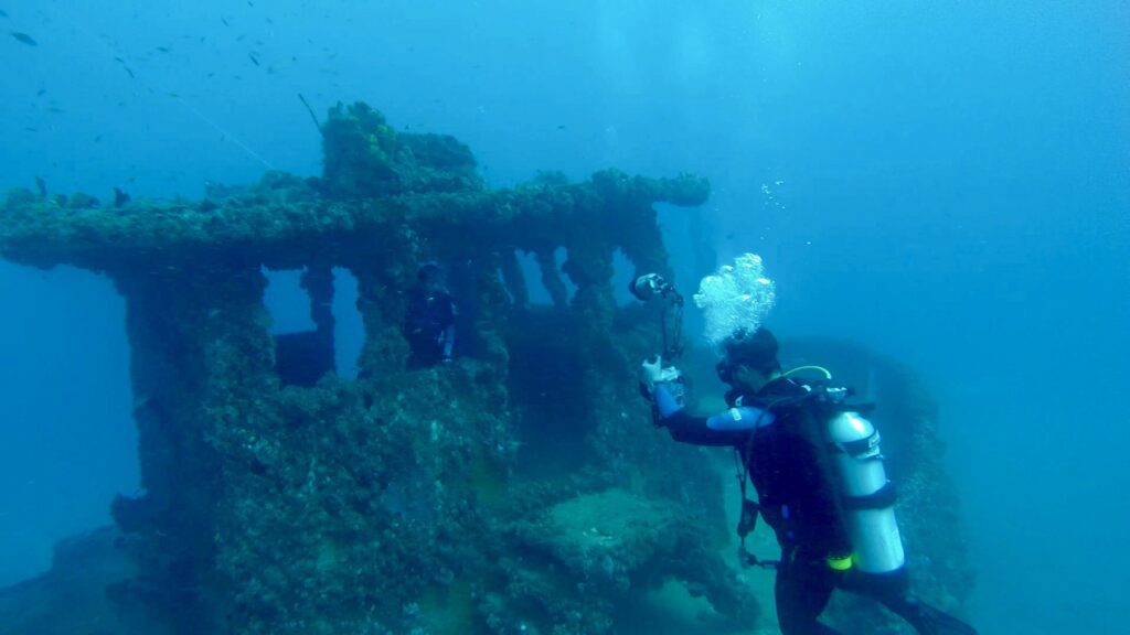 scuba diving taking photo of dive buddy on shipwreck in fort lauderdale