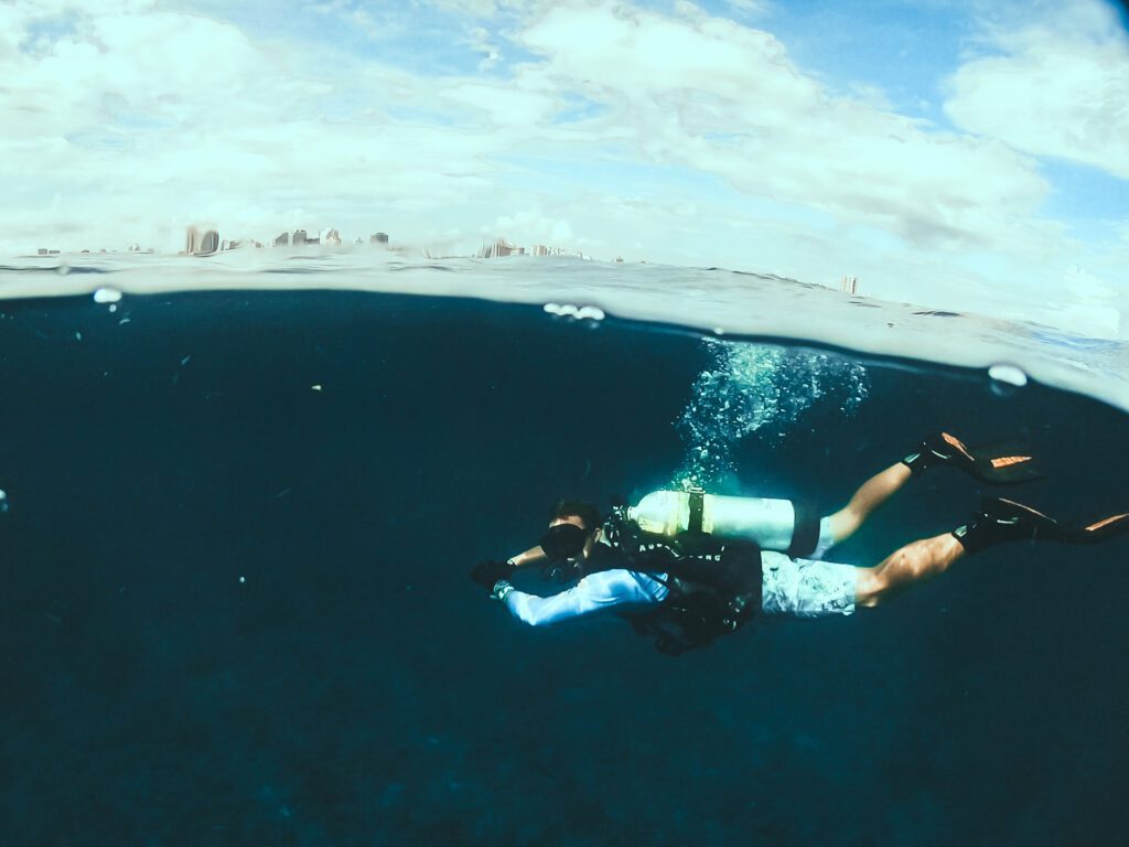 scuba diver below the surface with fort lauderdale in background