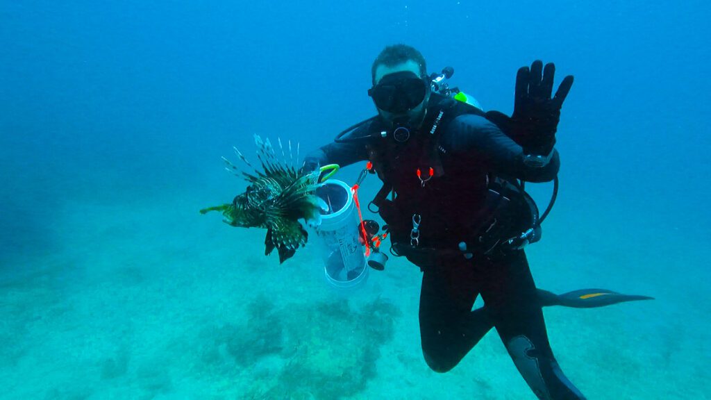 diver with lionfish and zookeeper in fort lauderdale beach