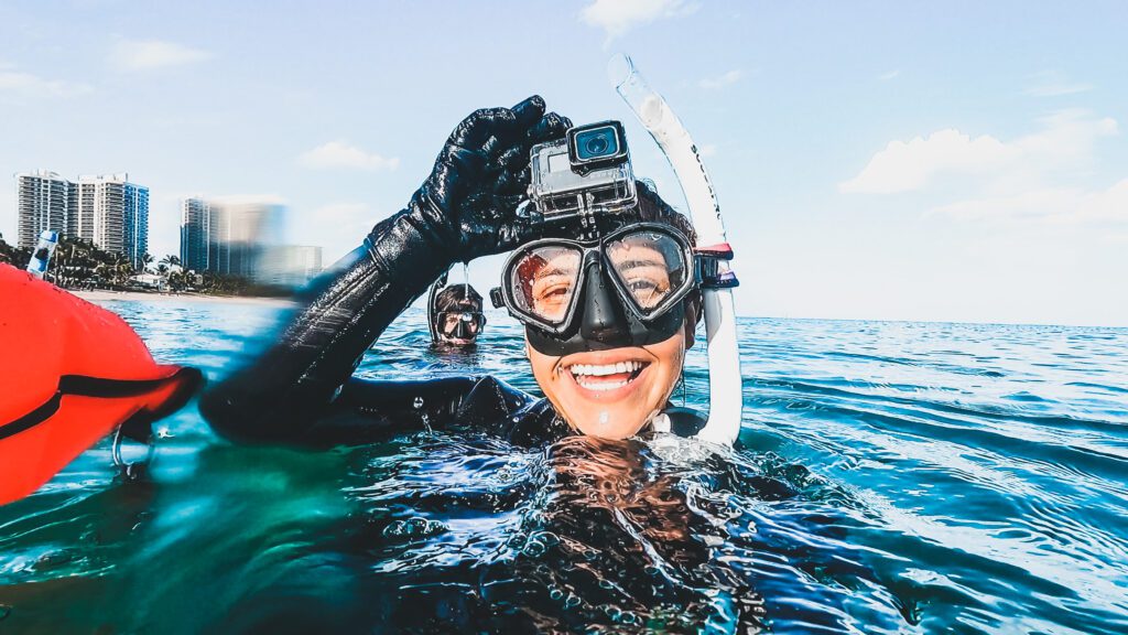 freediver with gopro smiling at the surface during beach dive