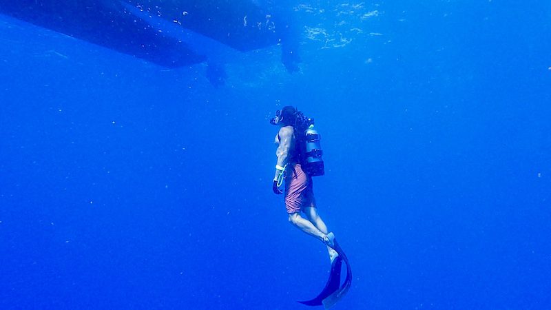 man ascending near boat in south florida scuba diving