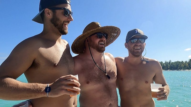three guys having a drink on a boat in punta cana
