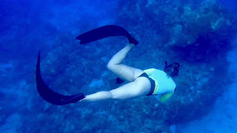 woman diving below the surface near mermaids chair st thomas usvi