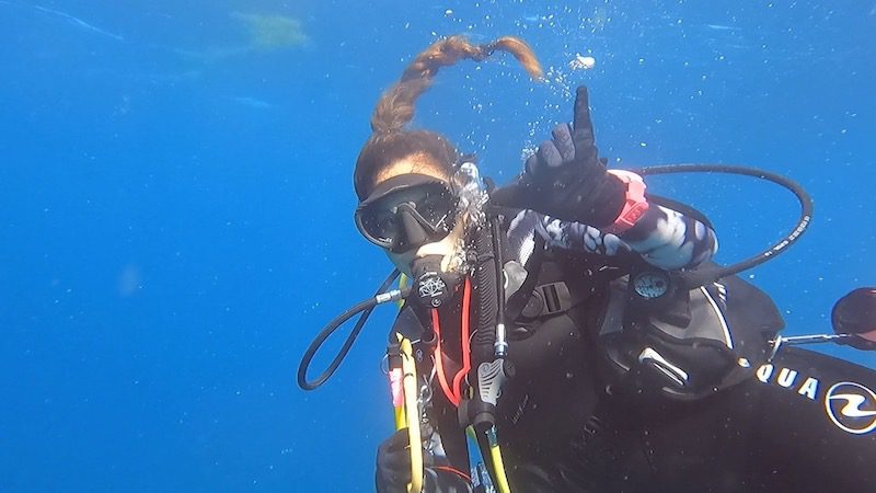 woman scuba diver underwater hang loose sign