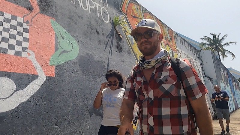 man and woman walking along mural walls of old san juan puerto rico