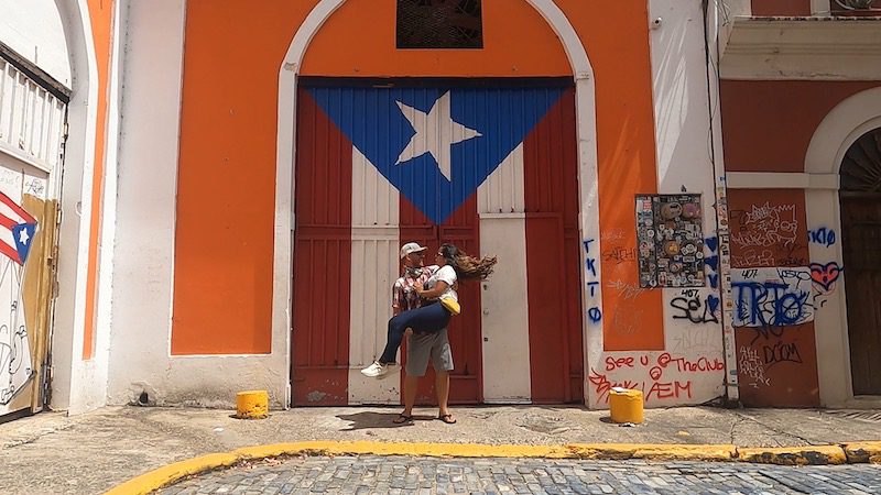 man holding woman in front of puerto rico flag door in old san juan puerto rico