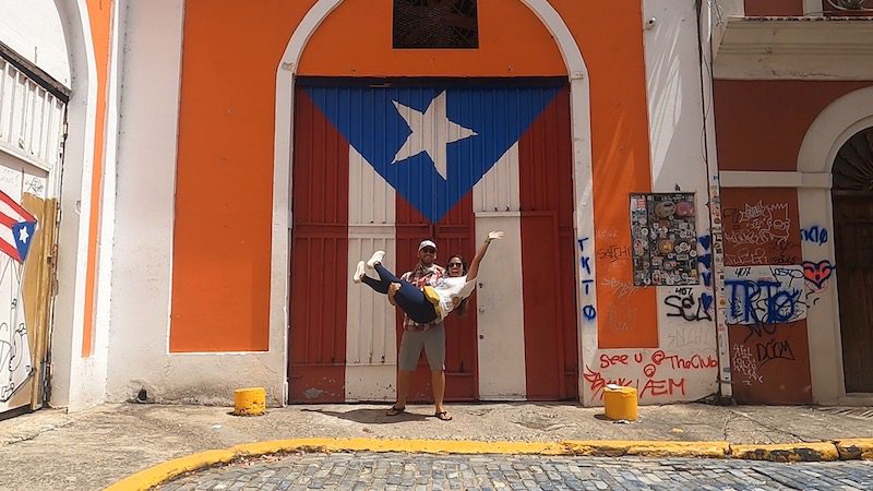 woman waving in front of puerto rican flag door old san juan