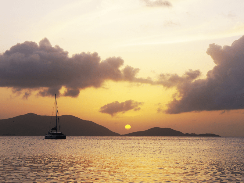 sunset in the virgin islands with a sailboat in front