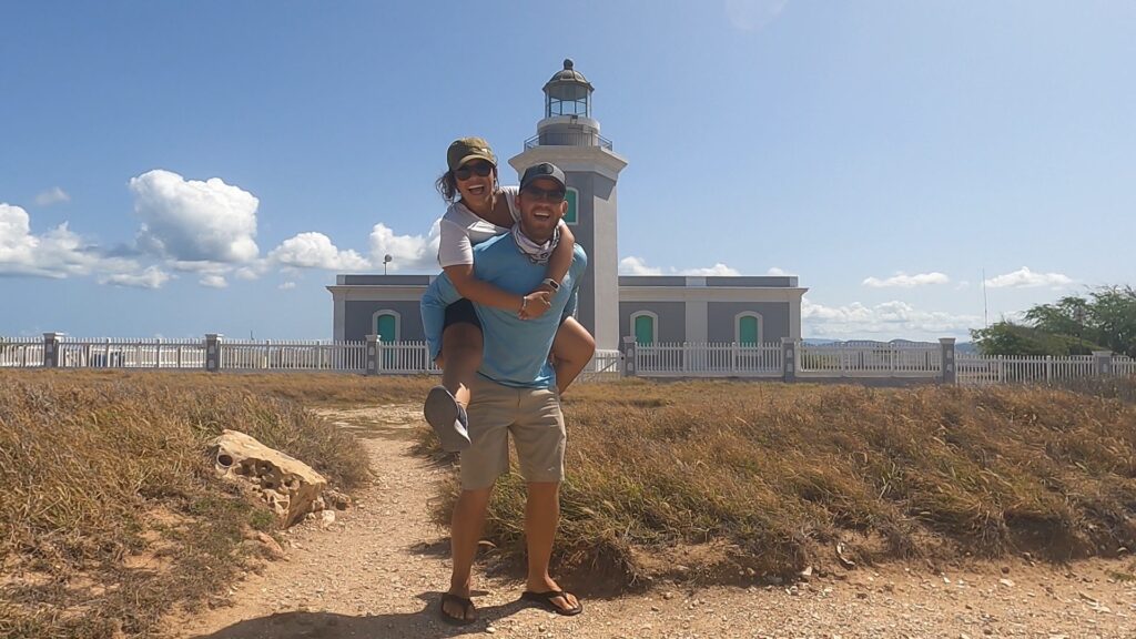 man and woman posing in front of faro los morrillos cabo rojo lighthouse
