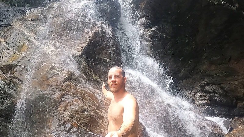 man showering in waterfall puerto rico san german charco el pilon